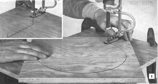 R - Abra una serie de agujeros, del tamaño de la hoja de la sierra, a 1/4 ó 1/2" entre sí, en una plancha de madera terciada de 3/4", e introduzca un clavo por abajo, para que sirva de eje de giro